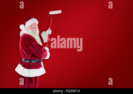 Immagine composita di Babbo Natale dipinge una parete Foto Stock