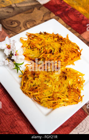 Latkes di patate servita con fiori di mandorla Foto Stock