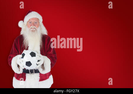 Immagine composita di santa detiene un classico football Foto Stock