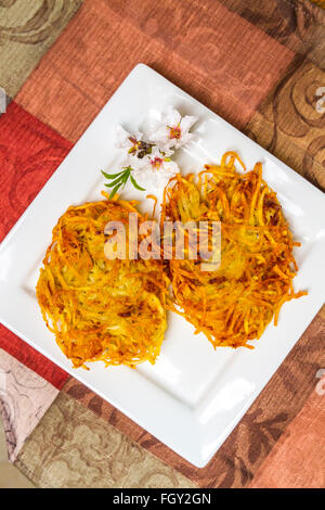 Latkes di patate servita con fiori di mandorla Foto Stock