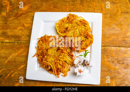 Latkes di patate servita con fiori di mandorla Foto Stock