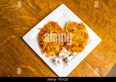 Latkes di patate servita con fiori di mandorla Foto Stock