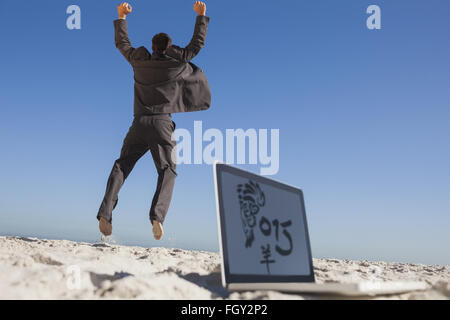 Immagine composita di imprenditore vittorioso jumping lasciando il suo computer portatile Foto Stock