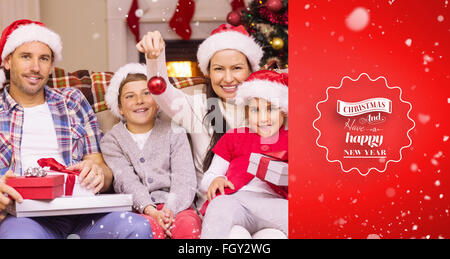 Immagine composita della famiglia felice indossando santa hat sul lettino Foto Stock