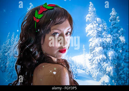 Signora giovane vestito per la stagione di natale e gli alberi di neve sullo sfondo Foto Stock