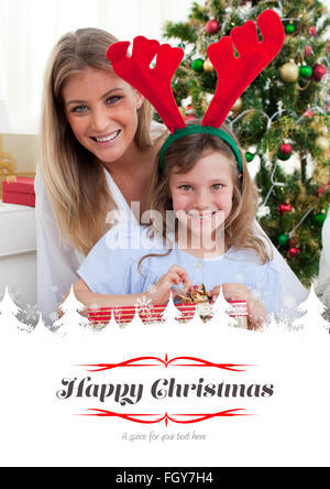 Immagine composita di sorridere madre e figlia di disimballare i regali di natale Foto Stock