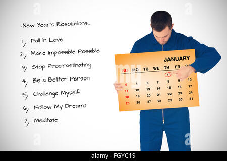 Immagine composita del giovanissimo meccanico nella caldaia suit puntando sul calendario nelle sue mani Foto Stock