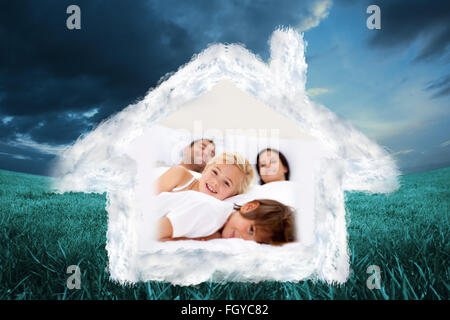 Immagine composita della famiglia rilassante nel letto dei genitori Foto Stock