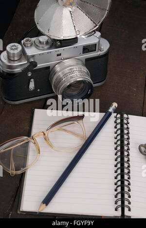 Concetti di una signora explorer , nota prenota, vecchia telecamera cinematografica, nota libro e matita. Foto Stock