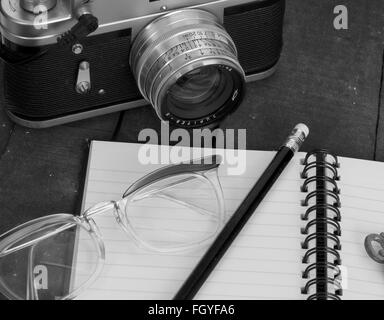 Concetti di una signora explorer , nota prenota, vecchia telecamera cinematografica, nota libro e matita. Foto Stock