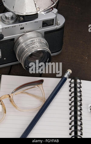 Concetti di una signora explorer , nota prenota, vecchia telecamera cinematografica, nota libro e matita. Foto Stock