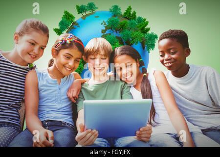 Immagine composita di bambini felici con tavoletta digitale presso il park Foto Stock