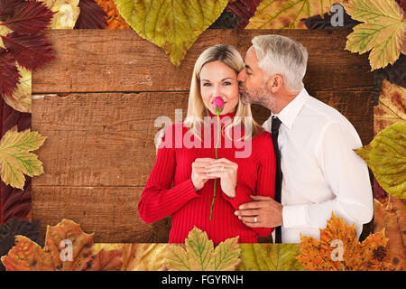 Immagine composita di uomo bello dando la sua moglie con un bacio sulla guancia Foto Stock