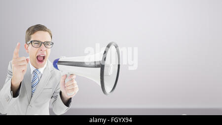 Immagine composita di geeky imprenditore urlando attraverso il megafono Foto Stock