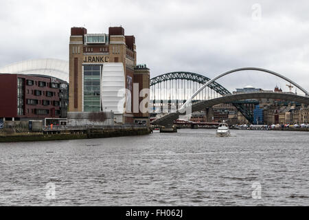 Una nave da diporto vele verso il basso del Tyne come il Gateshead Millennium Bridge viene sollevata con il Tyne Bridge in background Foto Stock