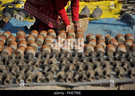 Kathmandu, Nepal. Il 22 febbraio, 2016. Una donna nepalese di essiccazione a vasi in ceramica quadrata in Bhaktapur dove piccola scala di ceramica tradizionale industria di produzione si trovano. Bhaktapur è una città antica nella valle di Kathmandu e viene elencato come un sito del Patrimonio Culturale Mondiale dell UNESCO per la sua ricca cultura, templi e il legno, il metallo e la pietra opere d'arte. © Narayan Maharjan/Pacific Press/Alamy Live News Foto Stock