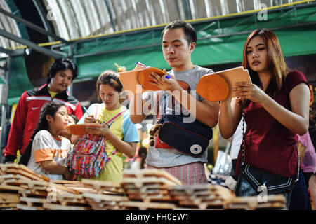 Bangkok, Tailandia. Il 22 febbraio, 2016. Le persone scrivono i loro desideri su tegole del tetto per essere donati a Wat Hua Lamphong di Bangkok, Thailandia, 22 febbraio, 2016. Come uno di Thailandia più importante festival buddista, Makha Bucha è osservati ogni notte di luna piena del terzo mese in Thai calendario lunare. Sul Makha Bucha giorno, popolo gregge di templi e venerare Buddha come anche pregare per la beatitudine. © Li Mangmang/Xinhua/Alamy Live News Foto Stock