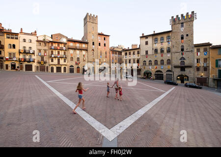 Una famiglia attraversando il declivio della Piazza Grande di Arezzo, Toscana, Italia. Foto Stock