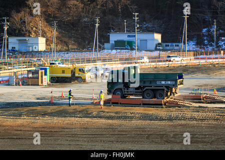 Costruzione camion e bulldozer ancora lavorare sulle zone danneggiate dal 2011 Grande Oriente Giappone Terremoto e Tsunami in Onagawa city il 11 febbraio 2016, Prefettura di Miyagi, Giappone. Un paio di settimane prima del quinto anniversario del 2011 Tohoku terremoto e dello tsunami, il governo giapponese ha annunciato che la seconda metà del lavoro di ricostruzione nell'area di Tohoku dovrebbe essere concluso prima del 2020 Tokyo Olimpiadi iniziare. Secondo la ricostruzione ufficiale sito web dell'Agenzia circa $ 250 miliardi di euro sono stati stanziati per il primo periodo (2011-2015) e 65 miliardi di dollari di più sono stati impostati Foto Stock