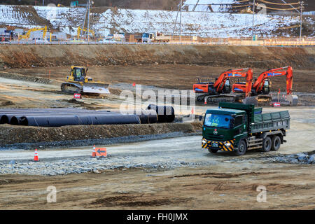 Costruzione camion e bulldozer ancora lavorare sulle zone danneggiate dal 2011 Grande Oriente Giappone Terremoto e Tsunami in Onagawa city il 11 febbraio 2016, Prefettura di Miyagi, Giappone. Un paio di settimane prima del quinto anniversario del 2011 Tohoku terremoto e dello tsunami, il governo giapponese ha annunciato che la seconda metà del lavoro di ricostruzione nell'area di Tohoku dovrebbe essere concluso prima del 2020 Tokyo Olimpiadi iniziare. Secondo la ricostruzione ufficiale sito web dell'Agenzia circa $ 250 miliardi di euro sono stati stanziati per il primo periodo (2011-2015) e 65 miliardi di dollari di più sono stati impostati Foto Stock