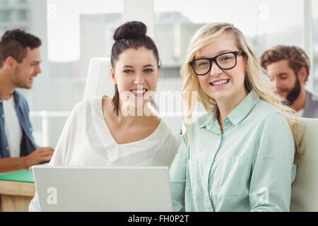 Ritratto di sorridere imprenditrici lavorando sul computer portatile Foto Stock