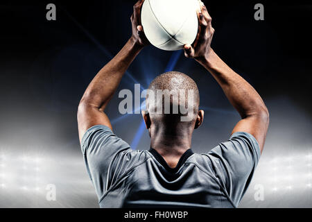 Immagine composita di sportivo gettando la sfera di rugby Foto Stock