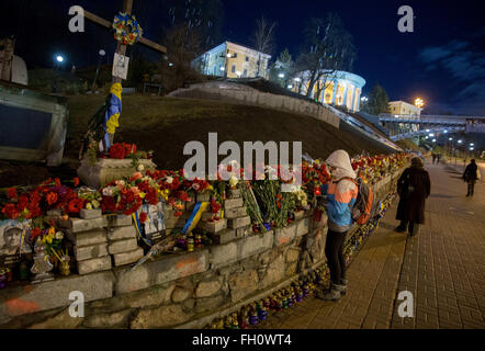 Kiev, Ucraina. Il 22 febbraio, 2016. Una donna che accende una candela e luoghi dei fiori sotto il Maidan Nezalezhnosti (lit. Independence Square) a Kiev, Ucraina, 22 febbraio 2016. Violenti scontri hanno avuto luogo in questa posizione due anni fa. Il ministro degli esteri tedesco Frank-Walter Steinmeier e il suo omologo francese Jean-Marc Ayrault proseguono la loro visita congiunta in Ucraina, che mira a mantenere la ex repubblica sovietica nel suo cammino verso la pro-europea di riforme. Foto: KAY NIETFELD/dpa/Alamy Live News Foto Stock