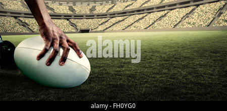 Immagine composita di immagine ritagliata di atleta tenendo palla da rugby Foto Stock