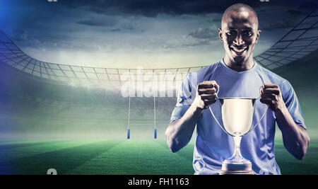 Immagine composita del ritratto di felice sportsman holding trophy Foto Stock