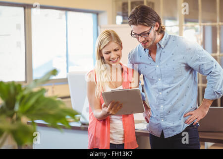 Imprenditrice mostrando qualcosa al collega di sesso maschile su tavoletta digitale Foto Stock