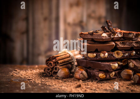 Still Life per il rotto della barra di cioccolato e spezie sul tavolo di legno Foto Stock