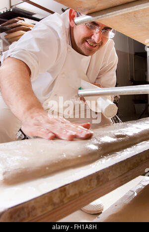 Baker fa il pane è stato impastato in forno Foto Stock