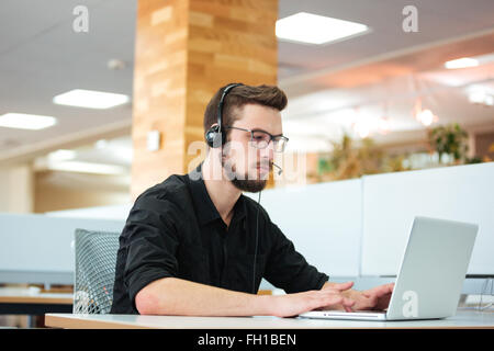 Imprenditore lavorando sul computer portatile in call center Foto Stock