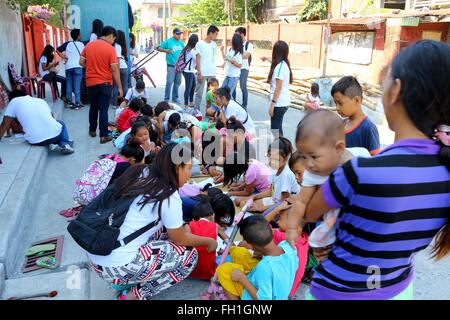 Un genitore che guarda la sua figlia mentre la dinamica Teen Company (DTC) volontari di insegnamento in Brgy. 5, Alonzo Street, Dalahikan, Cavite City. I fondatori di DTC trovano compimento che lentamente a crescere il numero di giovani che viene trasformato attraverso i loro programmi. Trasformate la gioventù, che hanno usato per essere tossicodipendenti, petty ladri, decontaminanti, bambini di strada, drop-out e out-of-scuola sono ora il DTC volontari e hanno restituito al sistema di istruzione tradizionale. Mentre alcuni dei bambini rimangono al di fuori della scuola che, almeno, sono in grado di accedere all'istruzione di base attraverso K4. (Foto di Gregorio B. Dantes Jr./Pacific P Foto Stock