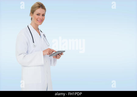 Immagine composita del biondo medico utilizzando tablet pc Foto Stock