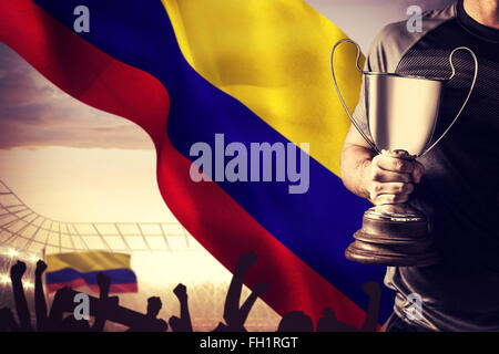 Immagine composita della sezione mediana di successo del giocatore di rugby trofeo holding e la sfera Foto Stock