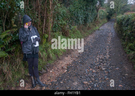 Un camminatore su Dartmoor colloqui sul suo telefono cellulare Foto Stock