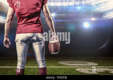 Immagine composita della sezione intermedia del giocatore di football americano con sfera Foto Stock