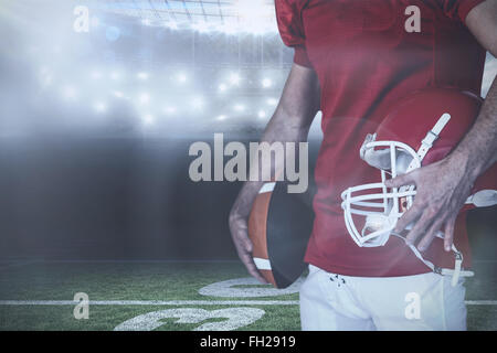 Immagine composita della sezione mediana del giocatore in possesso palla da rugby e casco Foto Stock
