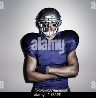 Immagine composita del ritratto di determinato giocatore di football americano con le braccia incrociate Foto Stock