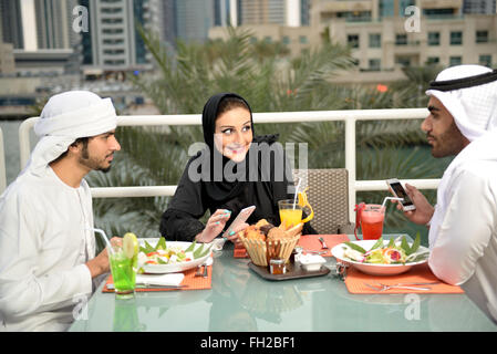 Emirati giovani amici arabi di pranzare in un ristorante Foto Stock