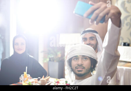 Emirati giovani amici arabi di pranzare in un ristorante Foto Stock