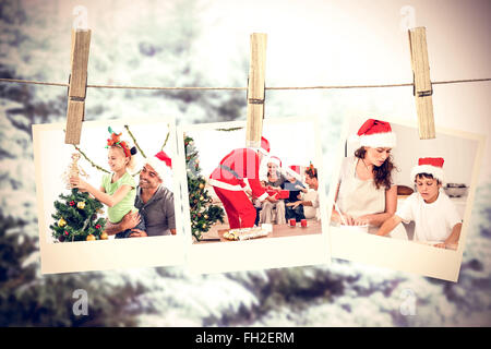 Immagine composita della cute bambina decorare l'albero di natale con suo padre Foto Stock