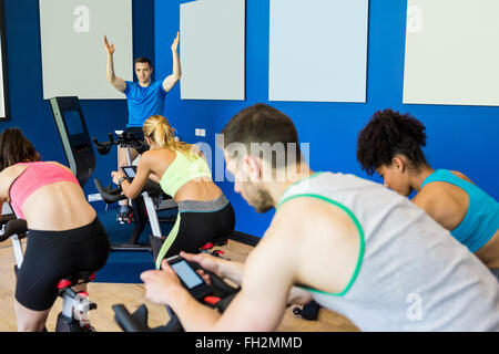 Montare la gente in una classe di spin Foto Stock