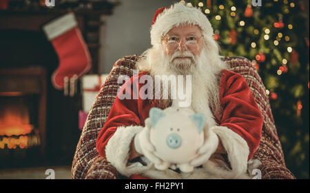 Sorridente santa offrendo salvadanaio Foto Stock