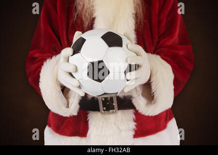 Immagine composita di santa detiene un classico football Foto Stock