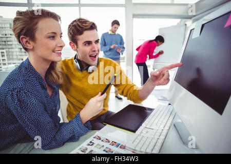 Graphic designer che indossano le cuffie alla scrivania Foto Stock