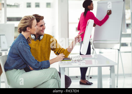 Graphic designer che indossano le cuffie alla scrivania Foto Stock