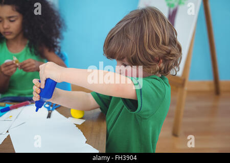 Piccolo boy utilizzando di arti e mestieri e materiali di consumo Foto Stock