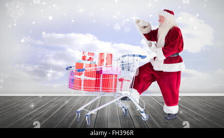 Immagine composita di santa offrire doni dal carrello Foto Stock